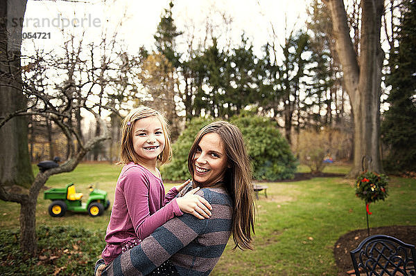 Porträt einer glücklichen Mutter mit Tochter im Garten