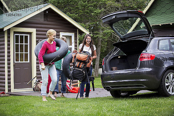 Glückliche Freunde laden Auto zum Camping