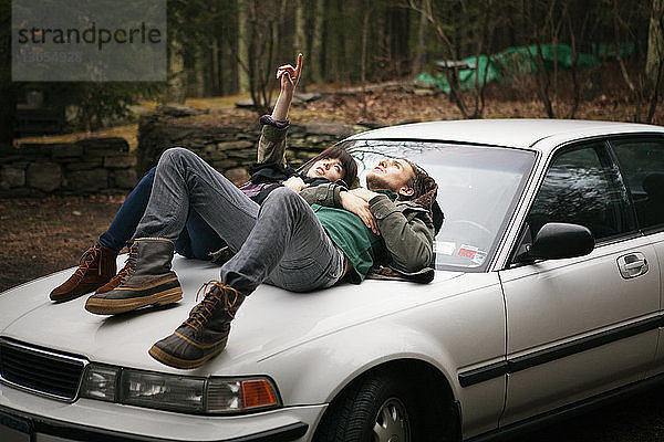 Ehepaar liegt auf Auto im Wald