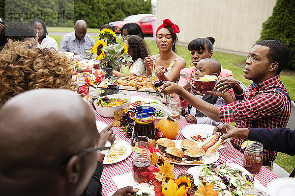 Familie und Freunde beim Essen am Picknicktisch