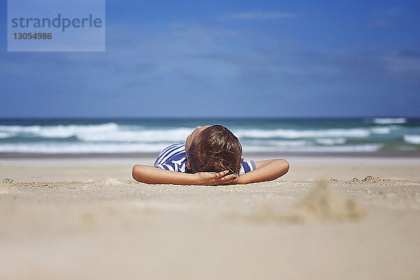 Oberflächenniveau eines Jungen  der sich an einem sonnigen Tag am Strand entspannt