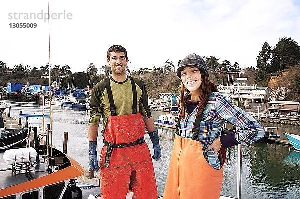 Porträt eines lächelnden Mannes und einer lächelnden Frau  die auf einem Fischerboot stehen