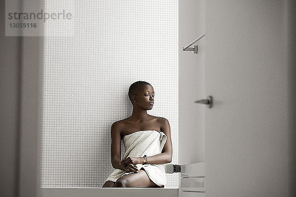 Frau mit geschlossenen Augen im Badezimmer sitzend
