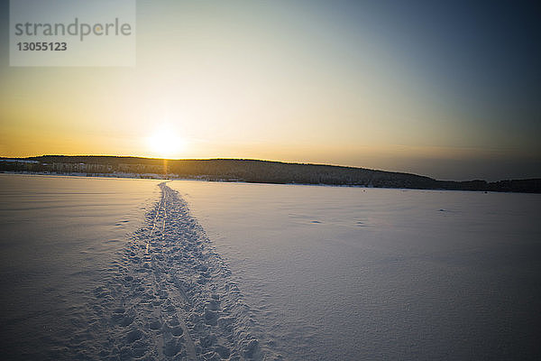 Spur auf schneebedecktem Feld gegen den Himmel