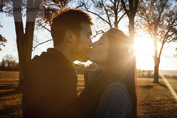 Seitenansicht eines zärtlichen Paares  das sich küsst  während es auf dem Spielfeld steht