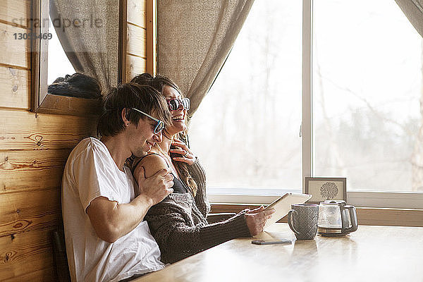 Glückliches Paar benutzt Tablet-Computer im Café