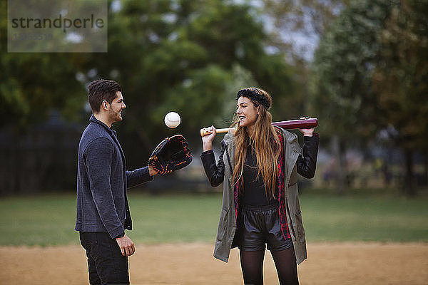 Paar spielt Baseball auf dem Spielfeld