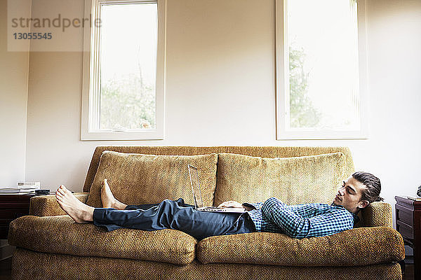Mann schläft zu Hause auf dem Sofa