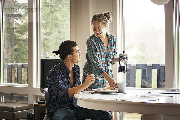Paar redet  während es zu Hause am Frühstückstisch sitzt