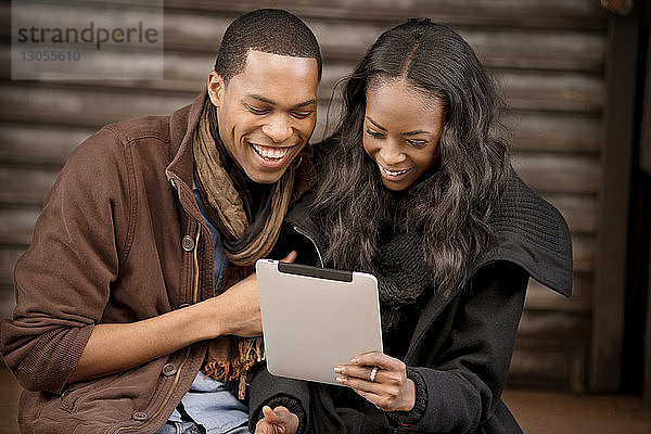 Glückliches Paar beim Blick auf das digitale Tablett