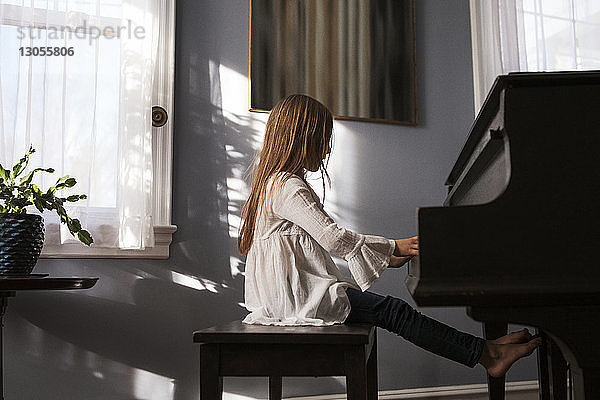 Seitenansicht eines zu Hause Klavier spielenden Mädchens