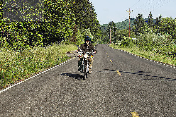 Motorrad fahrender Mann auf der Straße