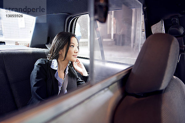 Nahaufnahme einer Geschäftsfrau  die durch ein Autofenster schaut