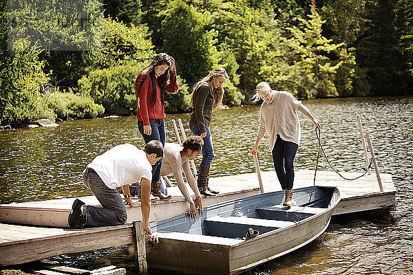 Freunde am Pier mit dem Boot auf dem See