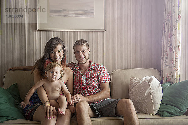 Porträt einer glücklichen Familie  die zu Hause auf dem Sofa sitzt