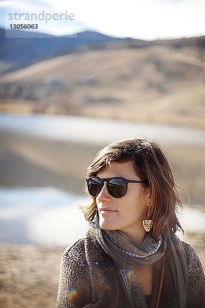 Frau mit Sonnenbrille gegen Berg an sonnigem Tag