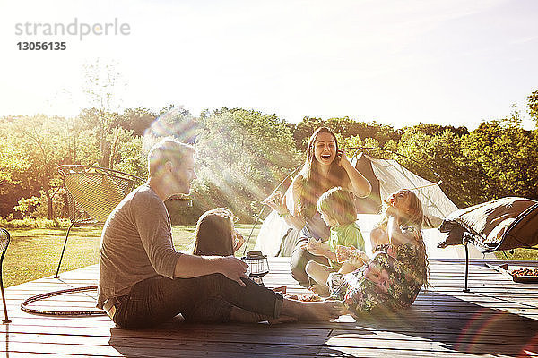 Glückliche Familie sitzt auf der Veranda