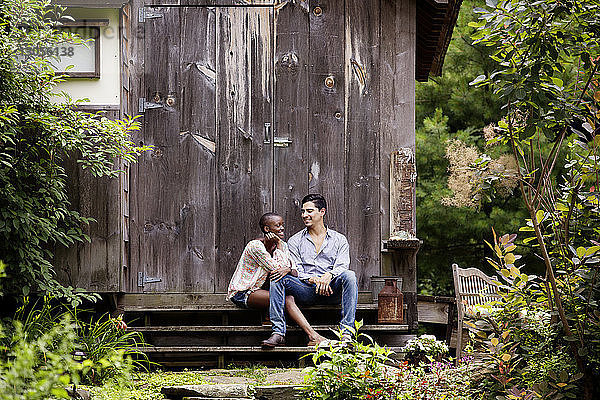 Lächelndes Paar sitzt im Hinterhof