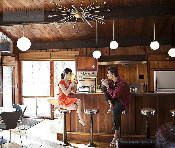 Ein Paar trinkt Kaffee  während es im Café auf einem Hocker sitzt