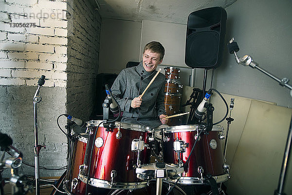 Glücklicher Mann spielt zu Hause Schlagzeug