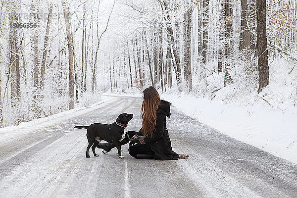Seitenansicht einer Frau mit Hund im Winter auf der Straße