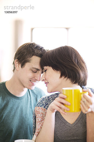Frau trinkt Kaffee  während sie mit ihrem Freund zu Hause sitzt