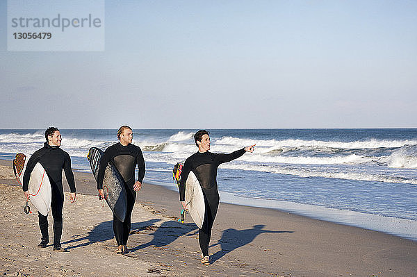 Surfer  die am Strand vor klarem Himmel an Land gehen