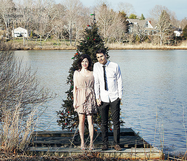 Porträt eines Ehepaares am Steg vor dem Weihnachtsbaum stehend