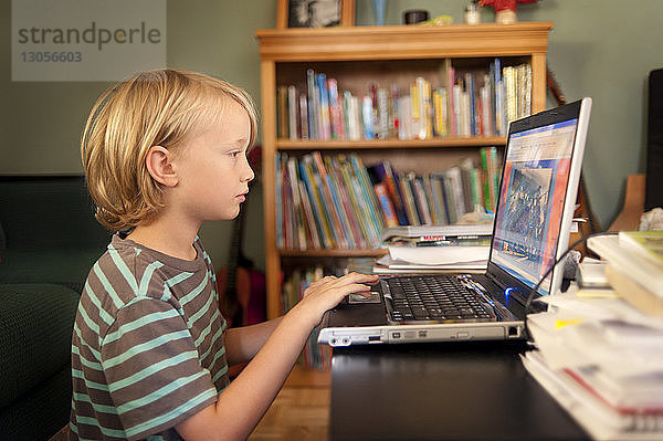 Junge benutzt Laptop-Computer zu Hause