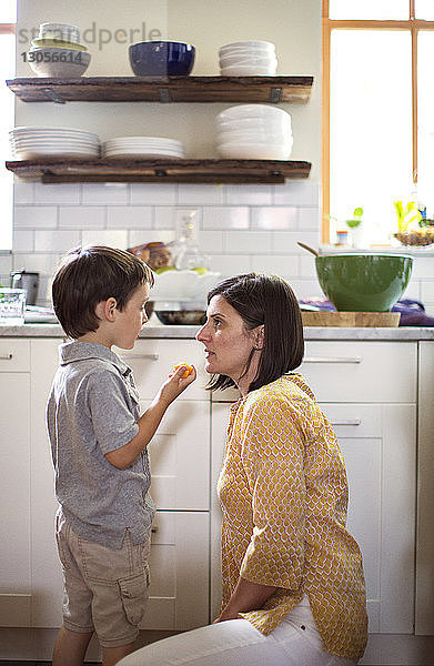 Junge spricht mit Mutter in der Küche