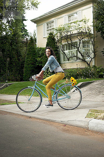 Frau schaut weg  während sie auf der Stadtstraße Fahrrad fährt