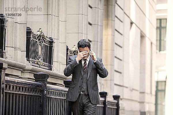Geschäftsmann beim Telefonieren auf der Straße in der Stadt