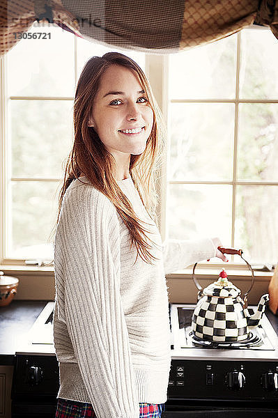 Porträt einer glücklichen Frau in der Küche in Seitenansicht