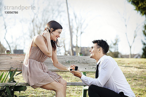 Mann macht seiner Freundin im Park einen Heiratsantrag