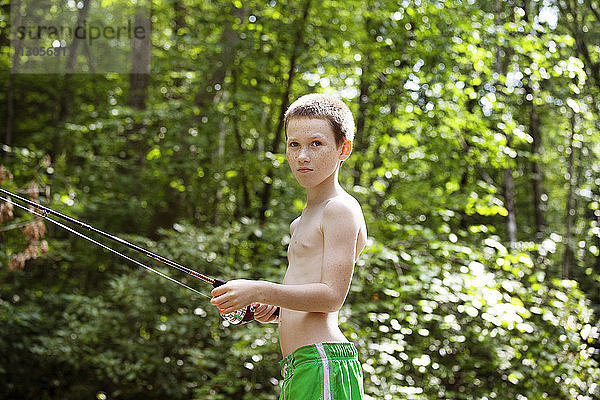 Seitenansicht eines Jungen beim Angeln im Wald