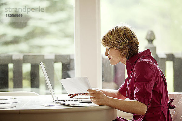 Frau benutzt Laptop-Computer für Online-Einkäufe zu Hause