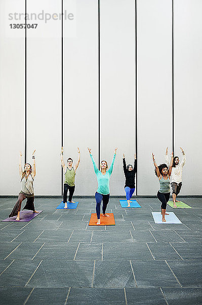 Personen  die im Yoga-Kurs trainieren