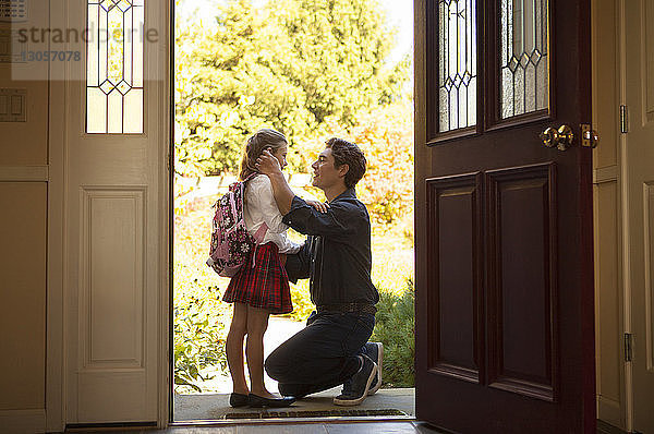 Seitenansicht eines Mannes mit Tochter am Eingang