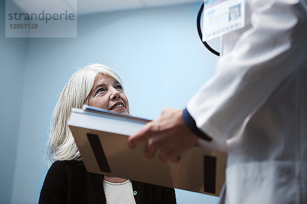 Ausgeschnittenes Bild eines Arztes im Gespräch mit einem Patienten im Krankenhaus