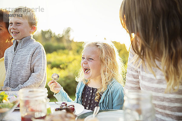 Mädchen genießt mit der Familie am Picknicktisch