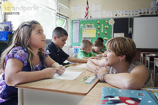 Lehrerin betrachtet Kinder beim Lernen in der Schule