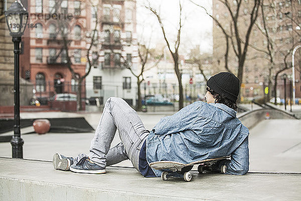 Rückansicht eines Mannes  der sich auf einem Sitz im Skateboard-Park entspannt