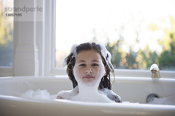 Porträt eines Mädchens  das zu Hause in der Badewanne sitzt