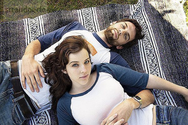 Porträt eines auf einer Decke liegenden Paares im Park