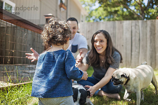 Glückliche Familie mit Hunden im Garten