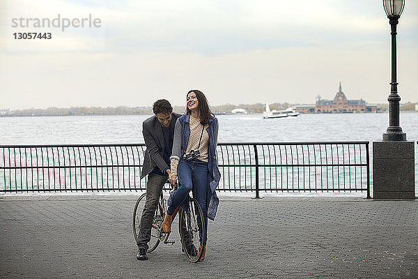 Paar mit Fahrrad auf der Promenade gegen den Hudson River