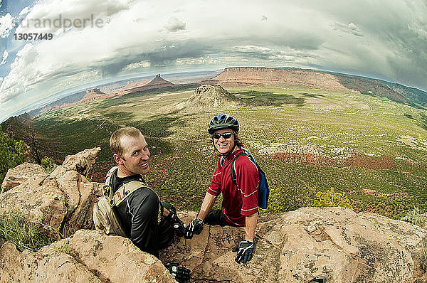 Hochwinkelaufnahme von Mountainbikern  die auf Felsen sitzen