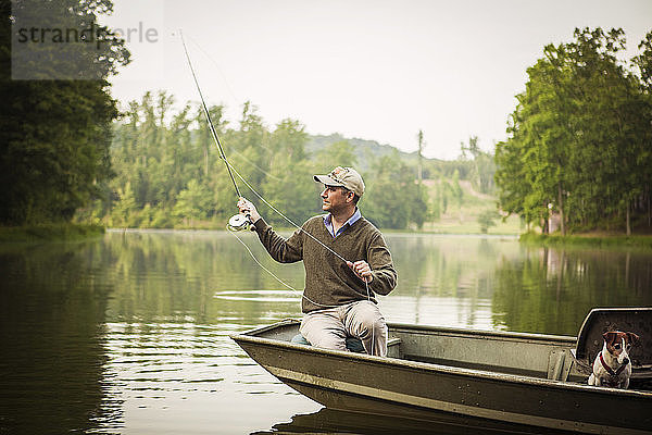 Mann wirft Angelrute aus  während er im See fischt