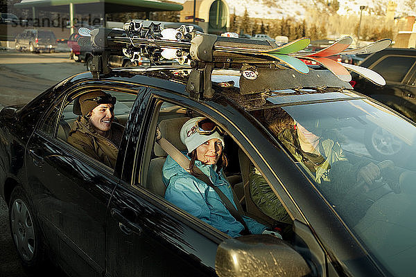 Glückliche Skifahrer sitzen im Auto