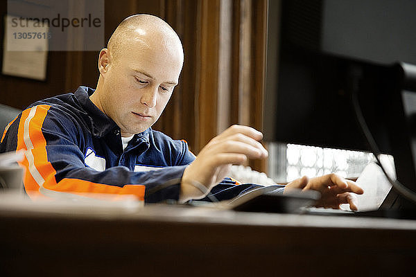 Schwerer Arbeiter am Tisch im Recyclingzentrum